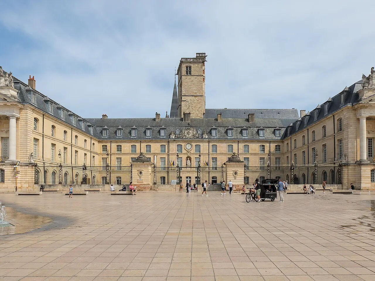 La place de la Libération à Dijon devant le palais des ducs et des États de Bourgogne, sa tour Philippe le Bon et quelques promeneurs.