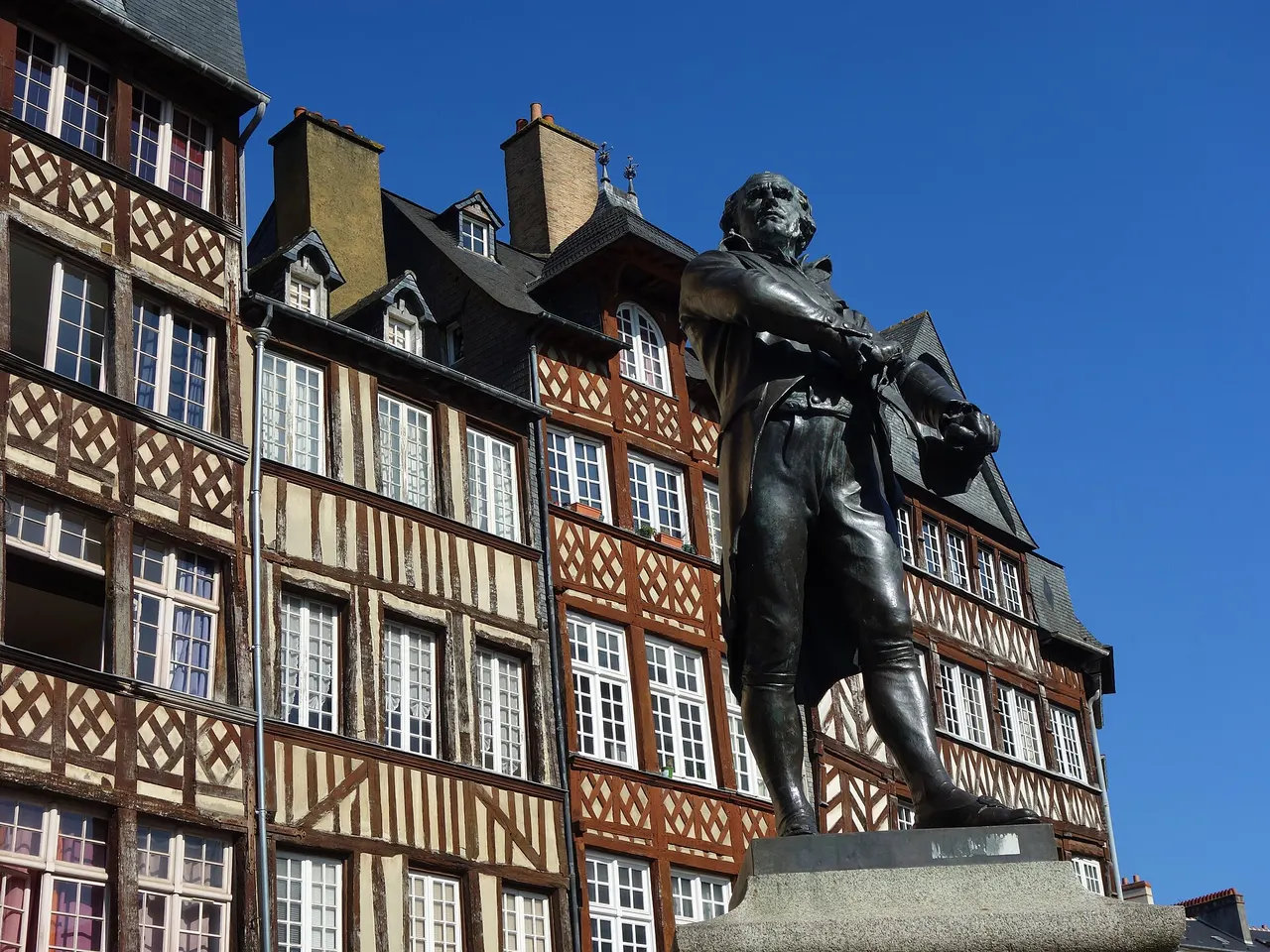 La statue en bronze de Leperdit sur la place du Champ-Jacquet, devant les maisons à pans de bois du centre de Rennes