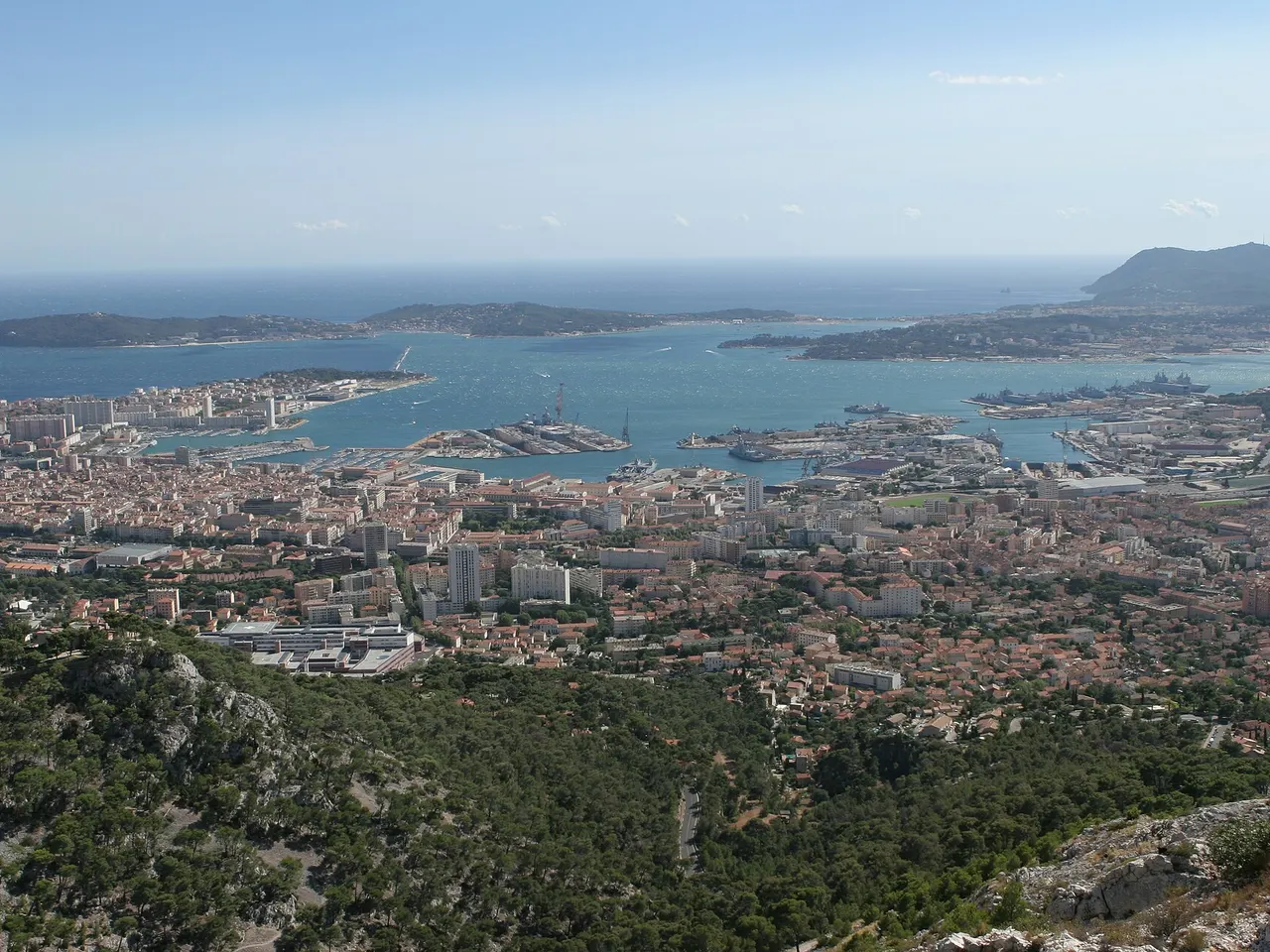La rade de Toulon vue des hauteurs boisées, avec la ville, le port militaire et la presqu’île de Saint-Mandrier.